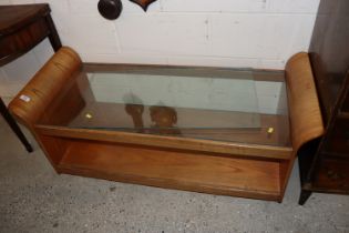 A teak and glass two tier coffee table, raised on
