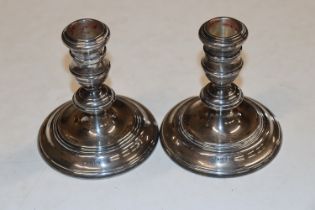 A pair of silver candlesticks with weighted bases