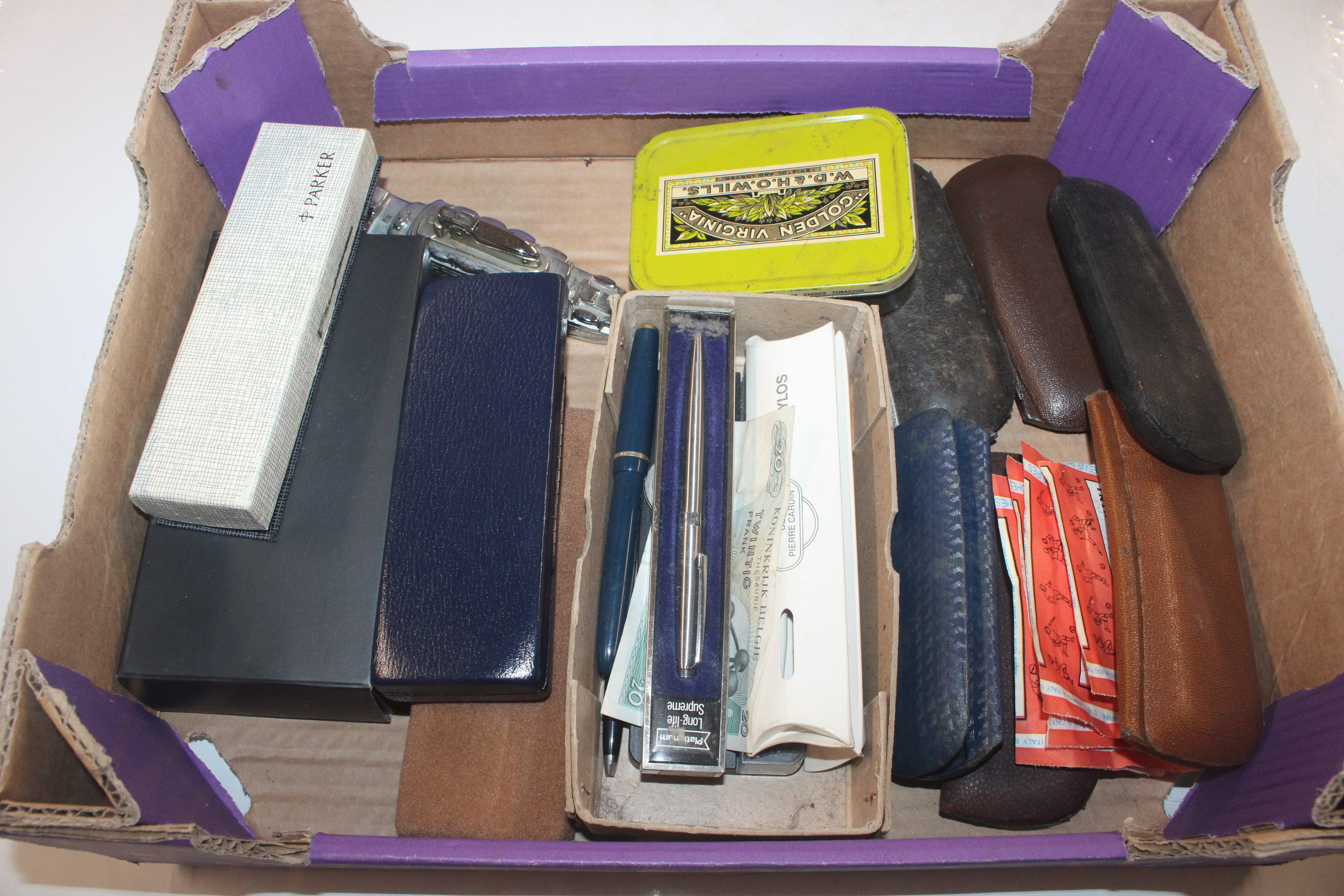 A box containing various glasses, a tin of coinage