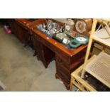 A mahogany twin pedestal writing desk with blue le