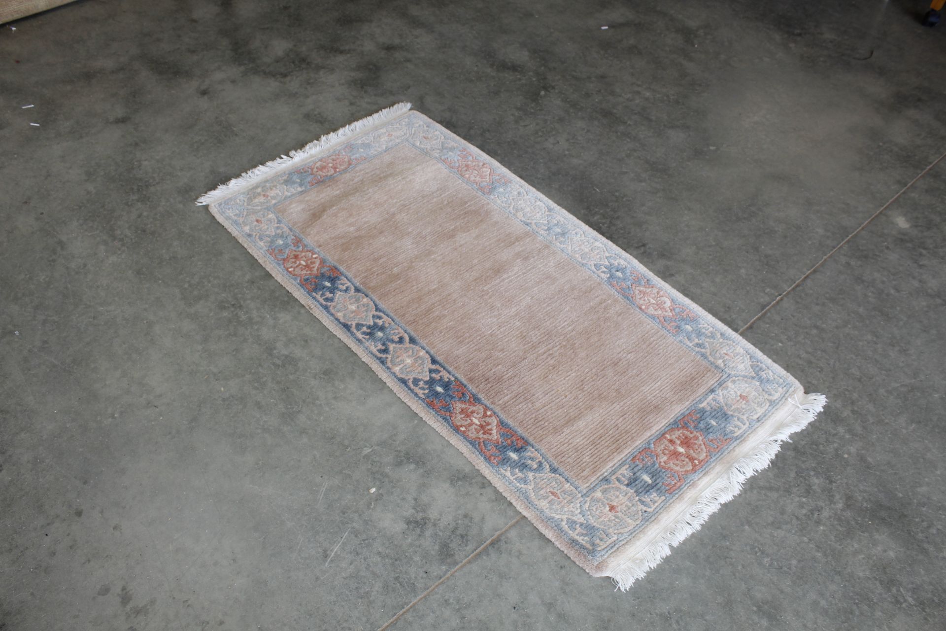 An approx. 5" x 2'4" patterned rug