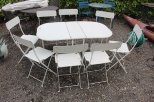 A metal folding garden table and set of eight matc