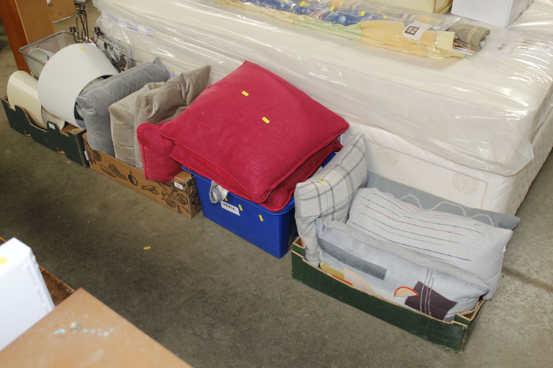 Three boxes containing cushions, blankets and thro