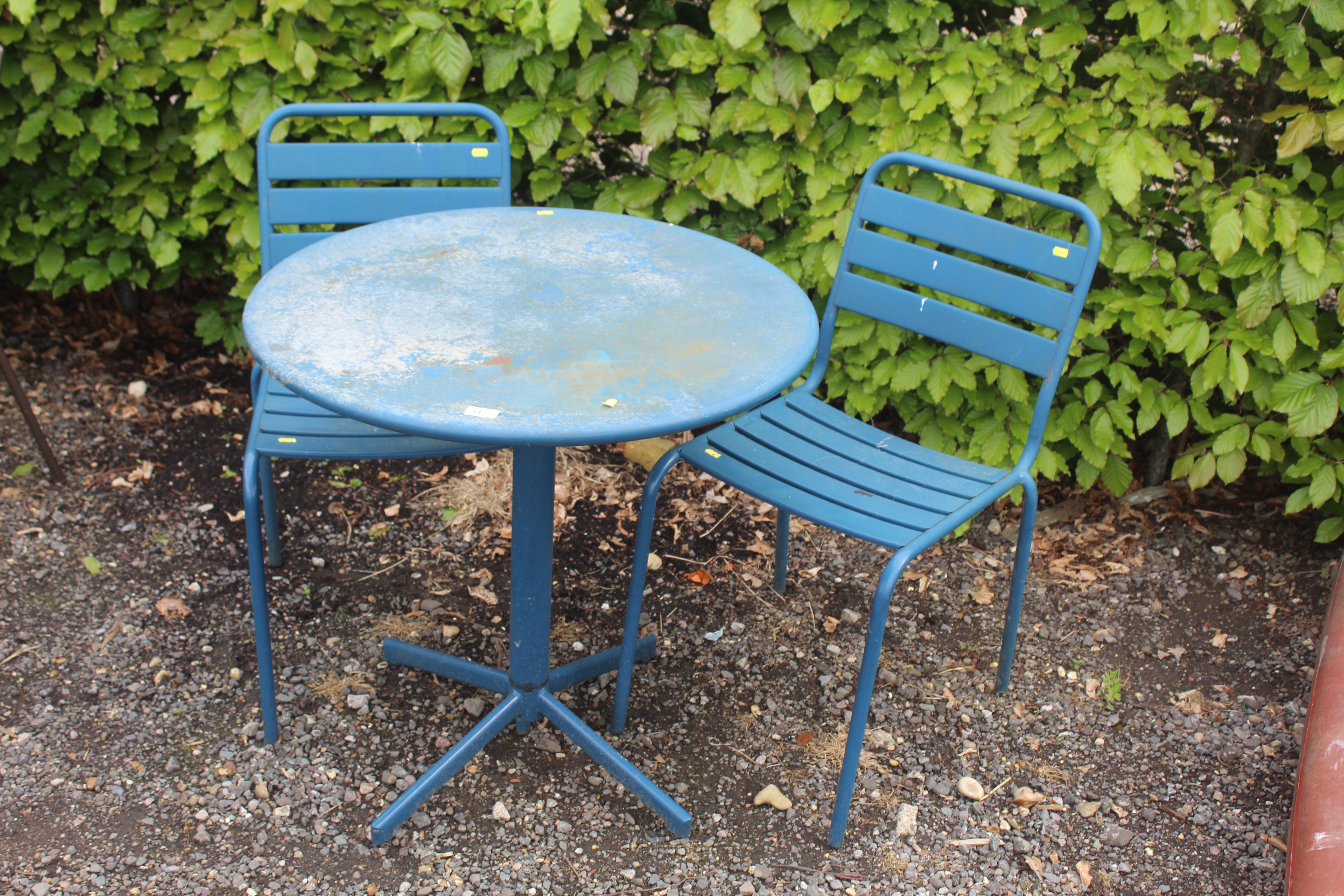 A small metal bistro set comprising circular table