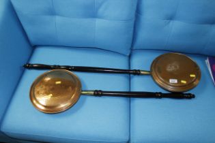 Two copper warming pans on turned handles