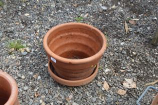 A ribbed terracotta plant pot and a terracotta sau