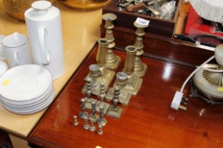 Three pairs of brass candlesticks and several mini