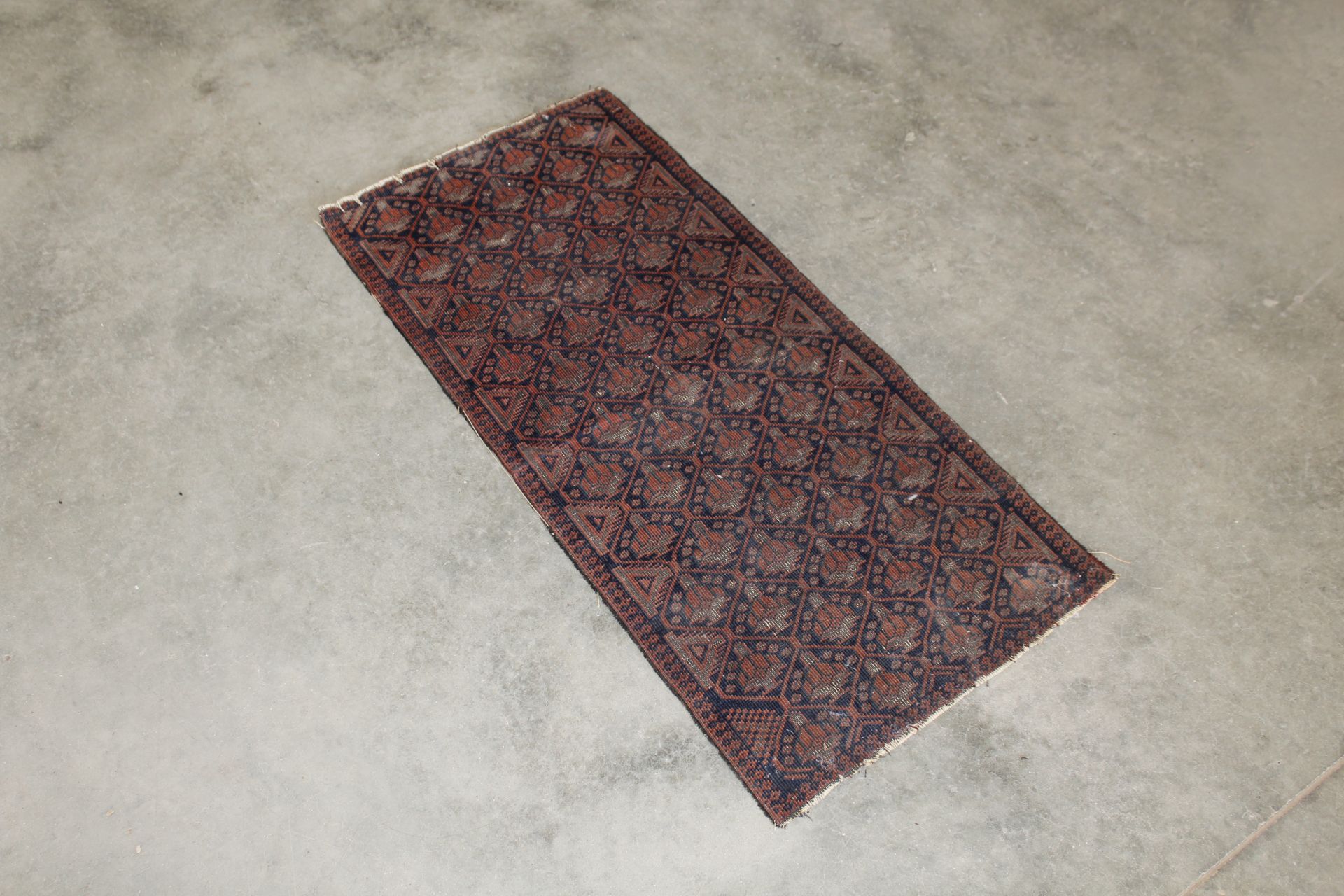 An approx. 3'7" x 1'8" patterned rug AF