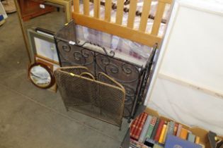 A brass fire guard and a wrought iron fire guard