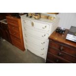 A cream and gilt bow fronted chest fitted five dra