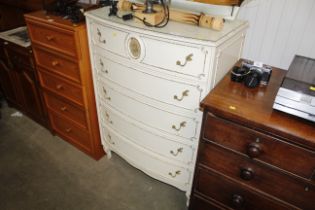 A cream and gilt bow fronted chest fitted five dra