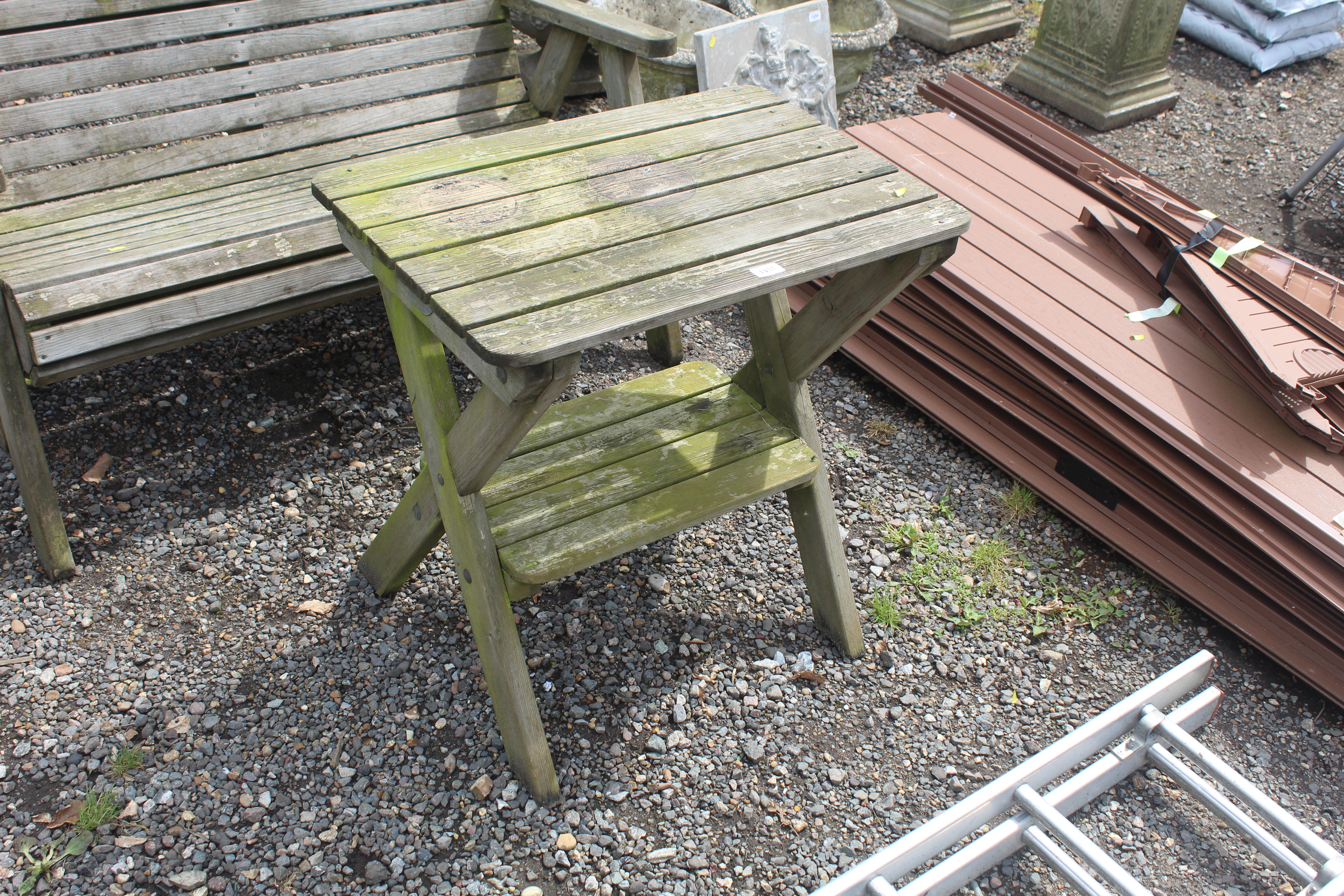 A wooden garden table fitted shelf below