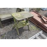 A wooden garden table fitted shelf below