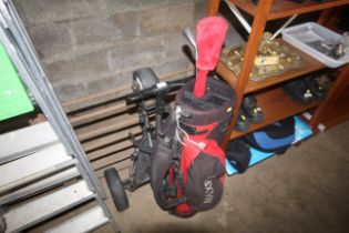 A Maxfli golf bag, two golf clubs and a folding Mo