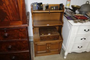 An Ercol graduated bookcase with covered base