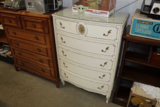 A cream and gilt bow fronted chest fitted five dra