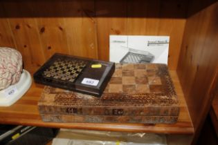 A travelling chess set and a leather covered book