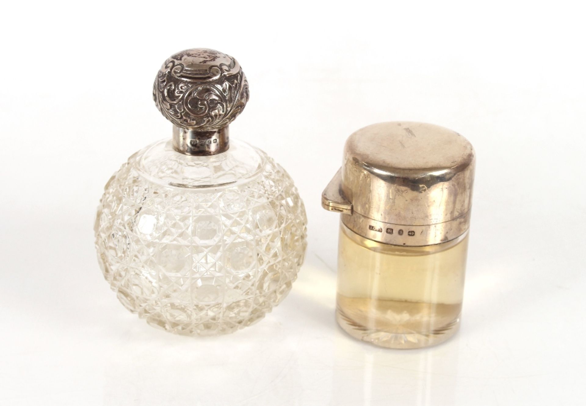 A late Victorian cut glass and silver mounted scent bottle, Birmingham 1898; and a cylindrical glass