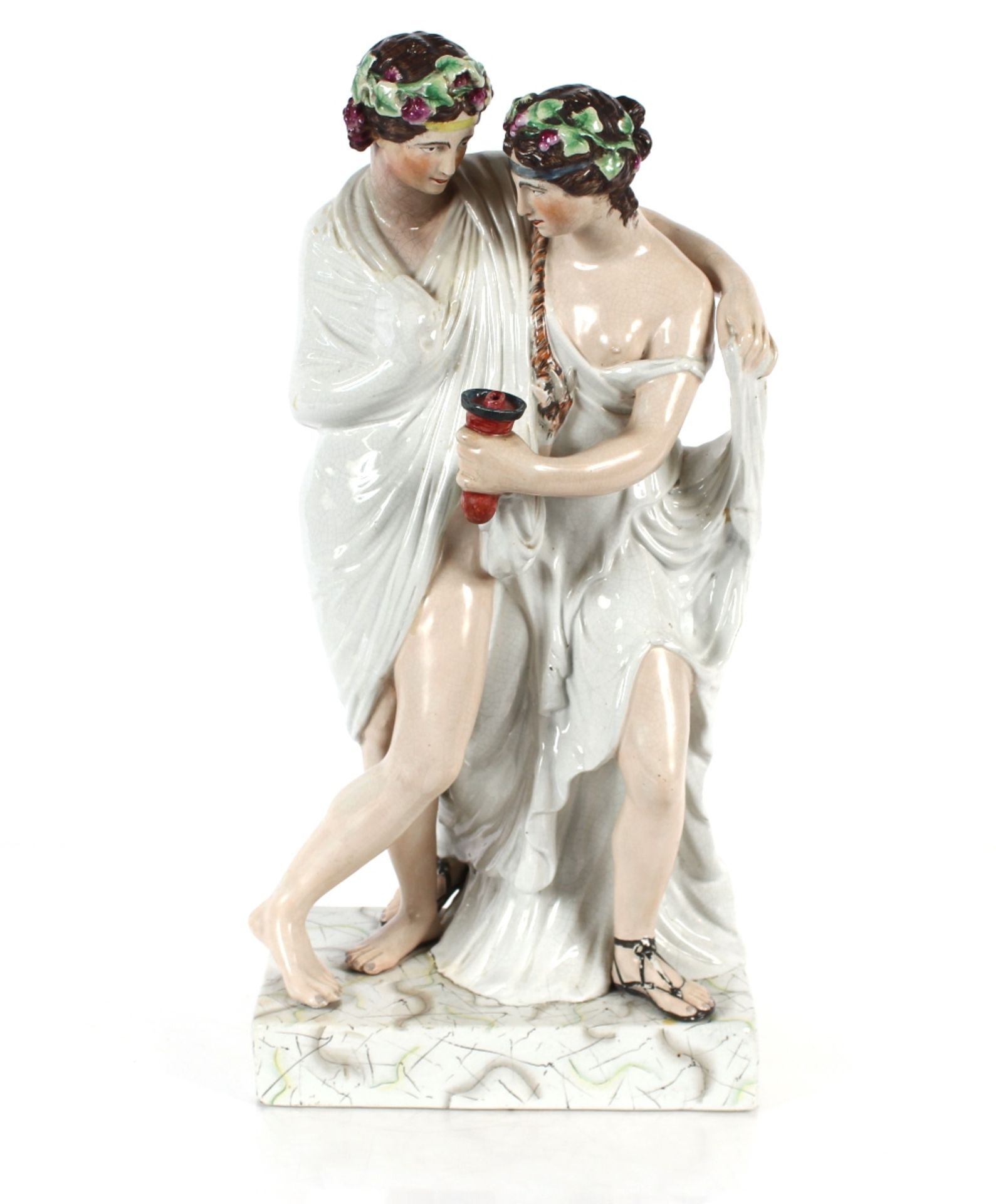 A large Staffordshire figure depicting a Bacchanalian couple, on plinth base, 64cm high
