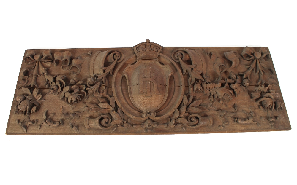 A 19th Century carved oak panel, having a central crest and shield with monogram, all over floral