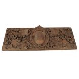 A 19th Century carved oak panel, having a central crest and shield with monogram, all over floral