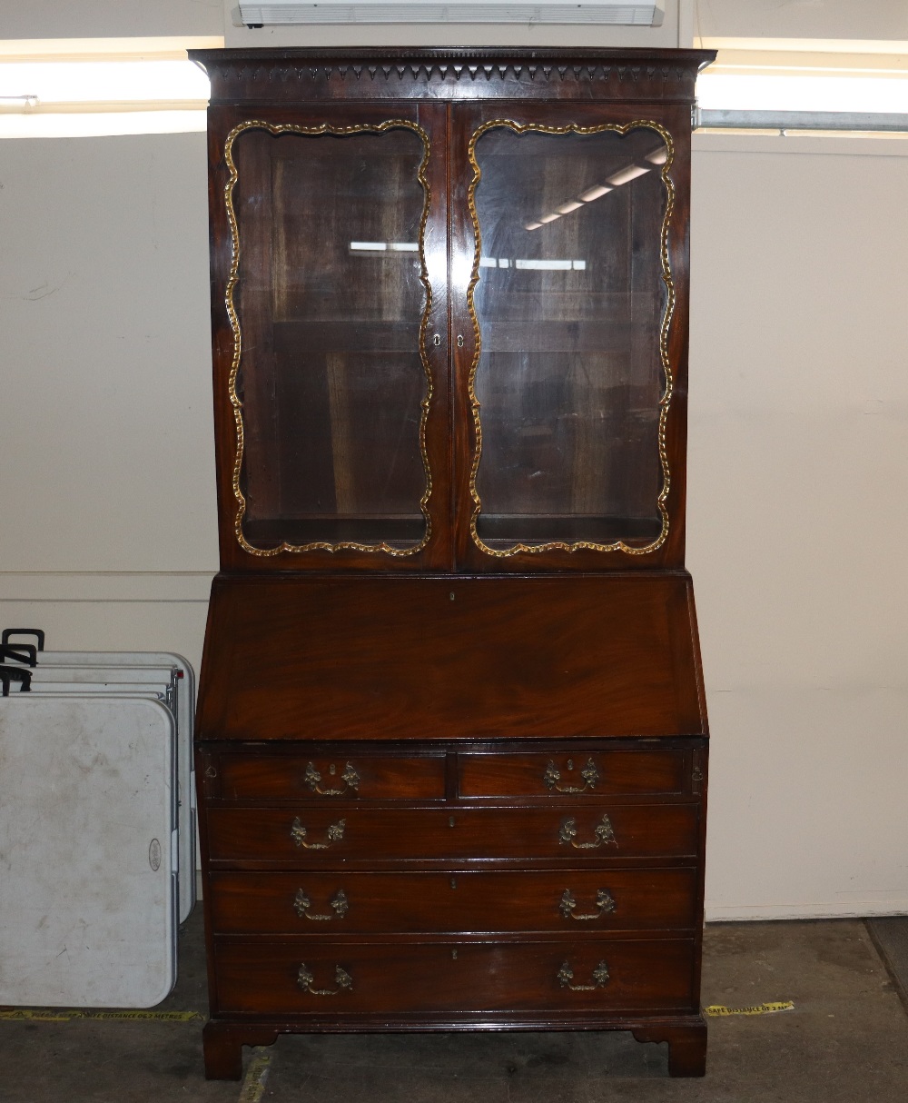 A George III style mahogany bureau bookcase, the upper glazed section enclosing shelves and drawers,