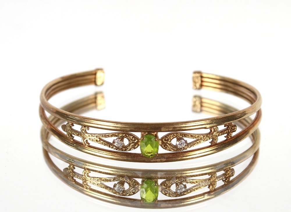 A 9ct gold peridot and white stone bangle, 10.7gms