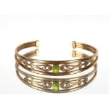 A 9ct gold peridot and white stone bangle, 10.7gms