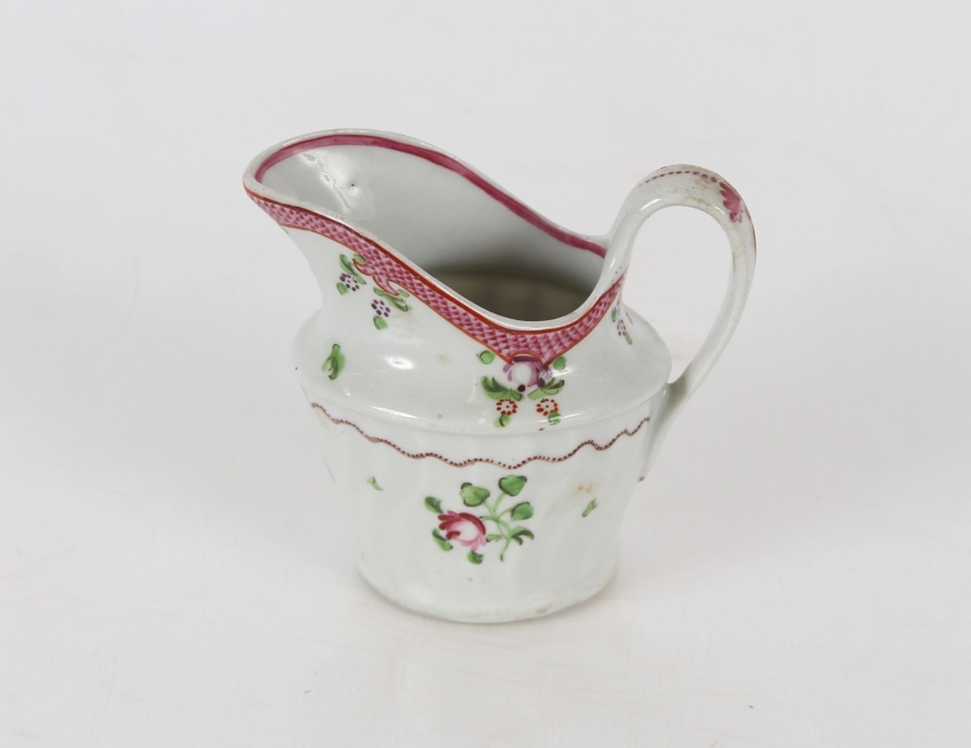 A Newhall porcelain cream jug, of fluted form, floral spray decoration marked N173 to base; and a