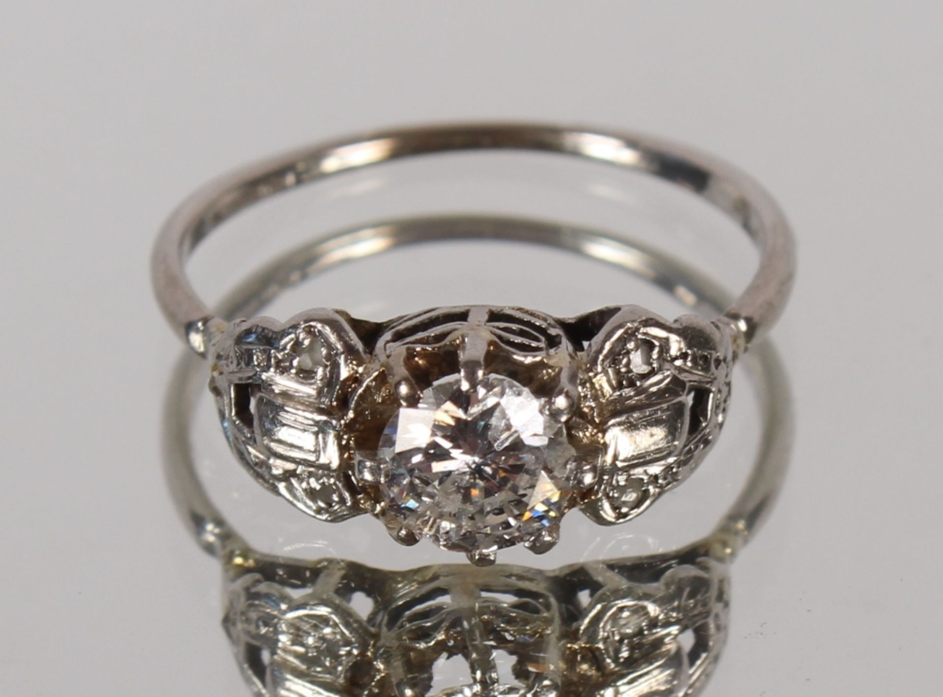 An Art Deco design cluster ring, having large central brilliant cut diamond, approx. ½carat, 3.9gms