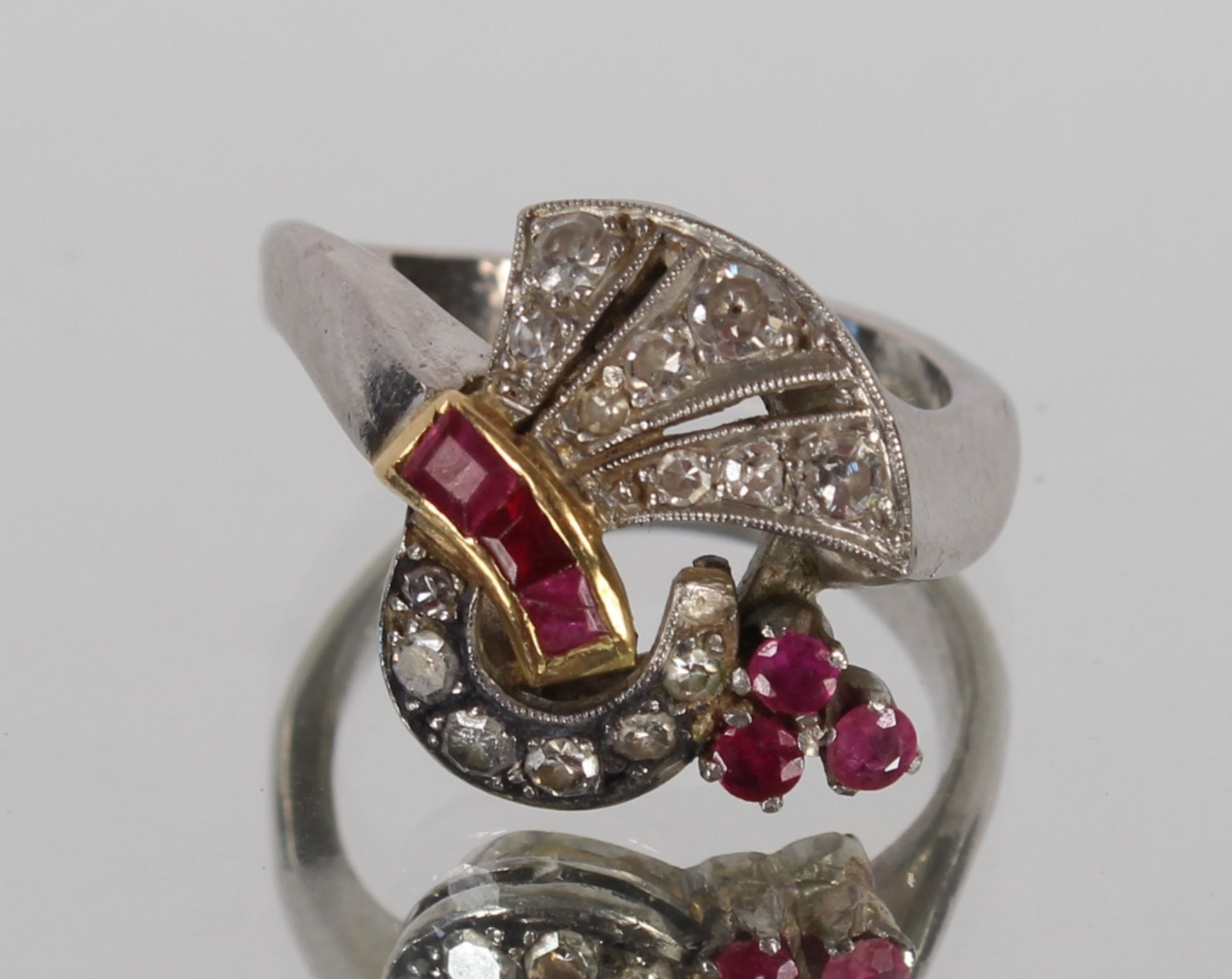 An Art Deco design diamond and ruby cluster ring, set to a white and yellow metal mount