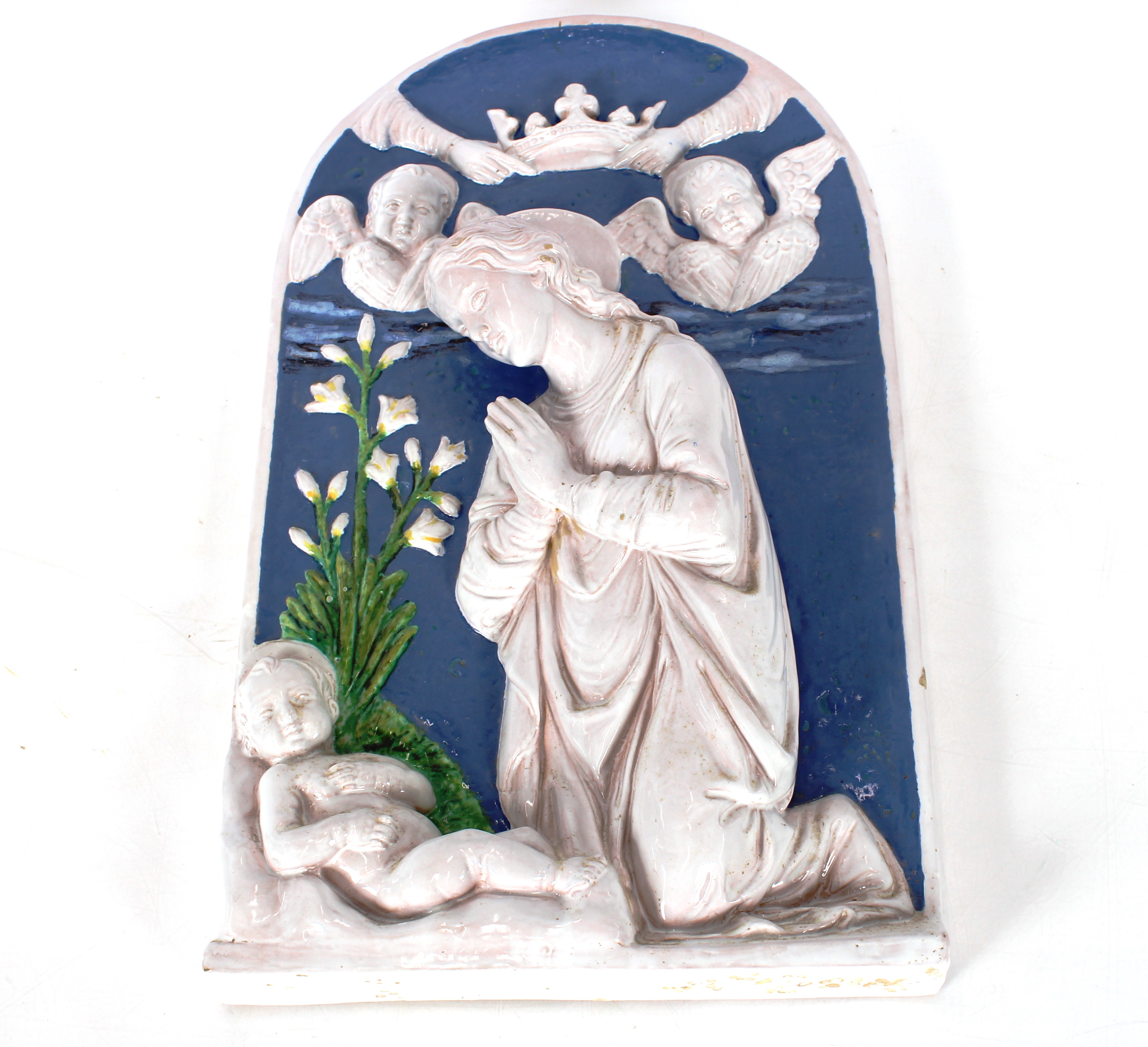 A blue and white Continental glazed pottery alcove plaque depicting a devotional scene, 48cm x 29cm