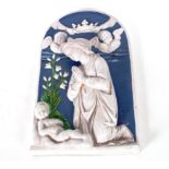 A blue and white Continental glazed pottery alcove plaque depicting a devotional scene, 48cm x 29cm