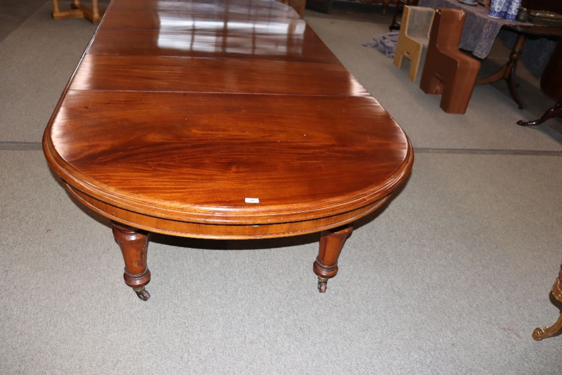 A large Victorian mahogany extending dining table with three extra leaves, raised on leaf carved and - Image 2 of 7