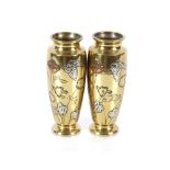 A pair of Oriental bronze baluster vases with white metal and copper inlay to the leaf decoration,