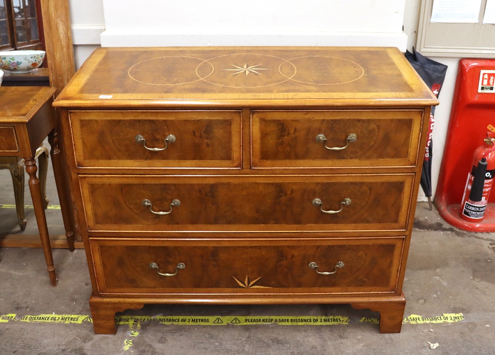 A walnut and inlaid cross banded chest of two short and two long drawers, raised on bracket feet,