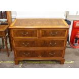 A walnut and inlaid cross banded chest of two short and two long drawers, raised on bracket feet,