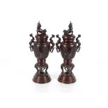 A pair of Oriental baluster bronze vases, the lids surmounted by Dogs of Fo, flanked by dragon