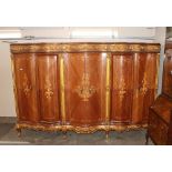 A large and unusual French marquetry and gilt decorated quadruple wardrobe of serpentine form,