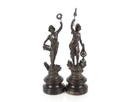 A pair of French spelter figures, raised on circular wooden plinths, 33cm high