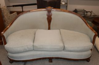 An early 20th Century carved walnut salon suite, comprising curved three seater settee with