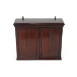 An Edwardian mahogany wall cupboard the interior adjustable shelf enclosed by a pair of sliding