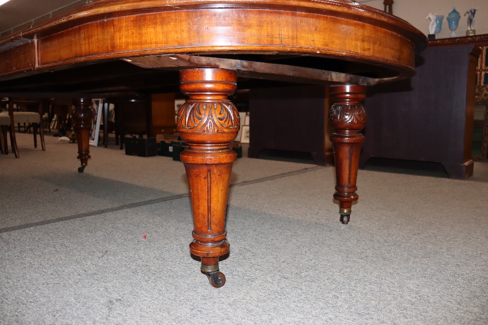 A large Victorian mahogany extending dining table with three extra leaves, raised on leaf carved and - Image 6 of 7