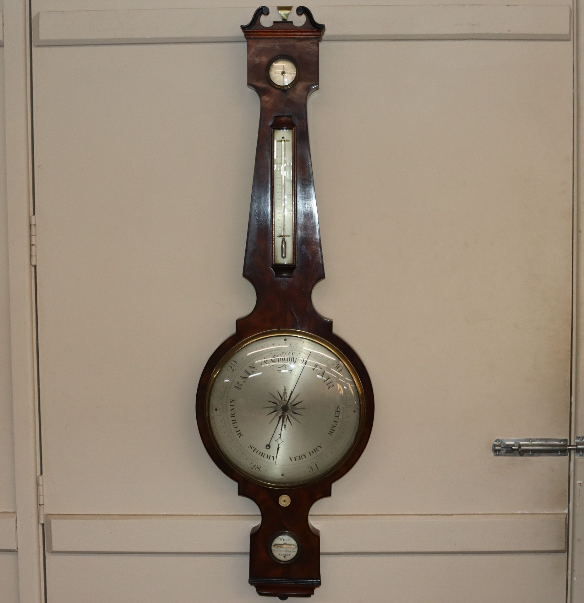 A 19th Century figured mahogany wheel barometer by West, Charing Cross, London, having large