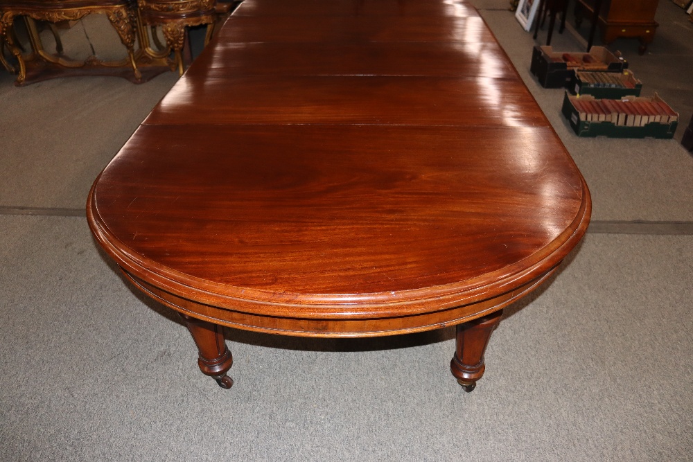 A large Victorian mahogany extending dining table with three extra leaves, raised on leaf carved and - Image 3 of 7
