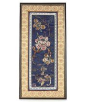 A framed and glazed Chinese embroidered section of a Mandarin's cloak decorated flowers and dragons,