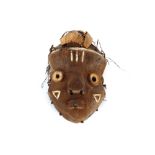 A soft wood carved and painted Ethnic tribal face mask with husk decoration, 29cm