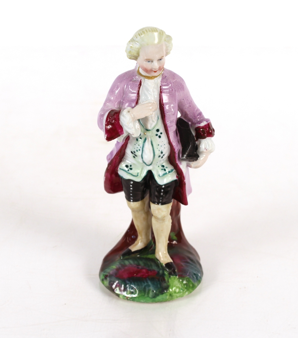 Continental porcelain figure group of a gentleman in breeches reclining against a tree stump;
