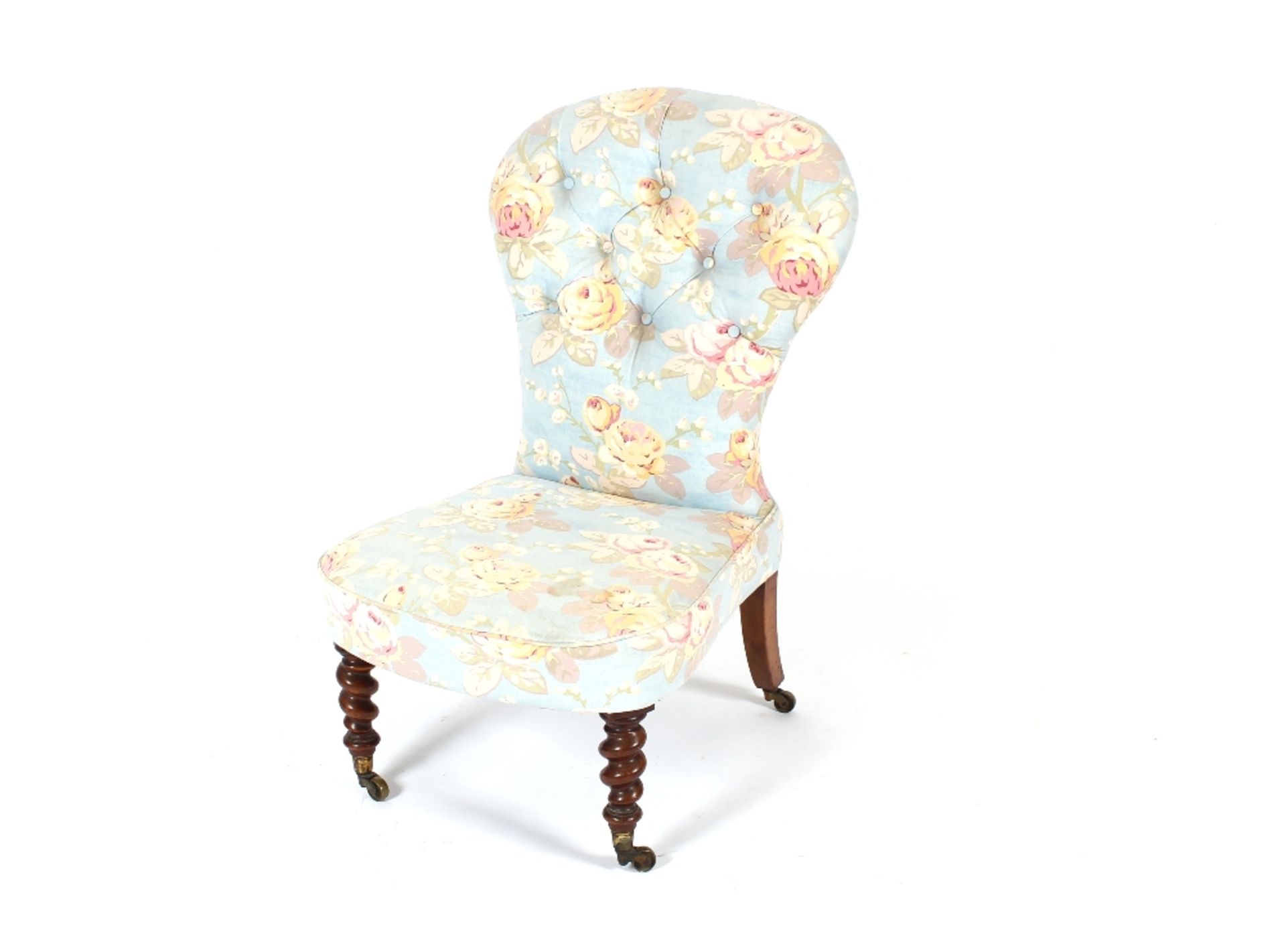 A Victorian walnut framed nursing chair, having shaped buttoned back and bow fronted seat, raised on