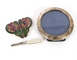 A circular silver photograph frame; a silver blade